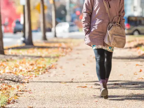 Woman walking down street in autumn