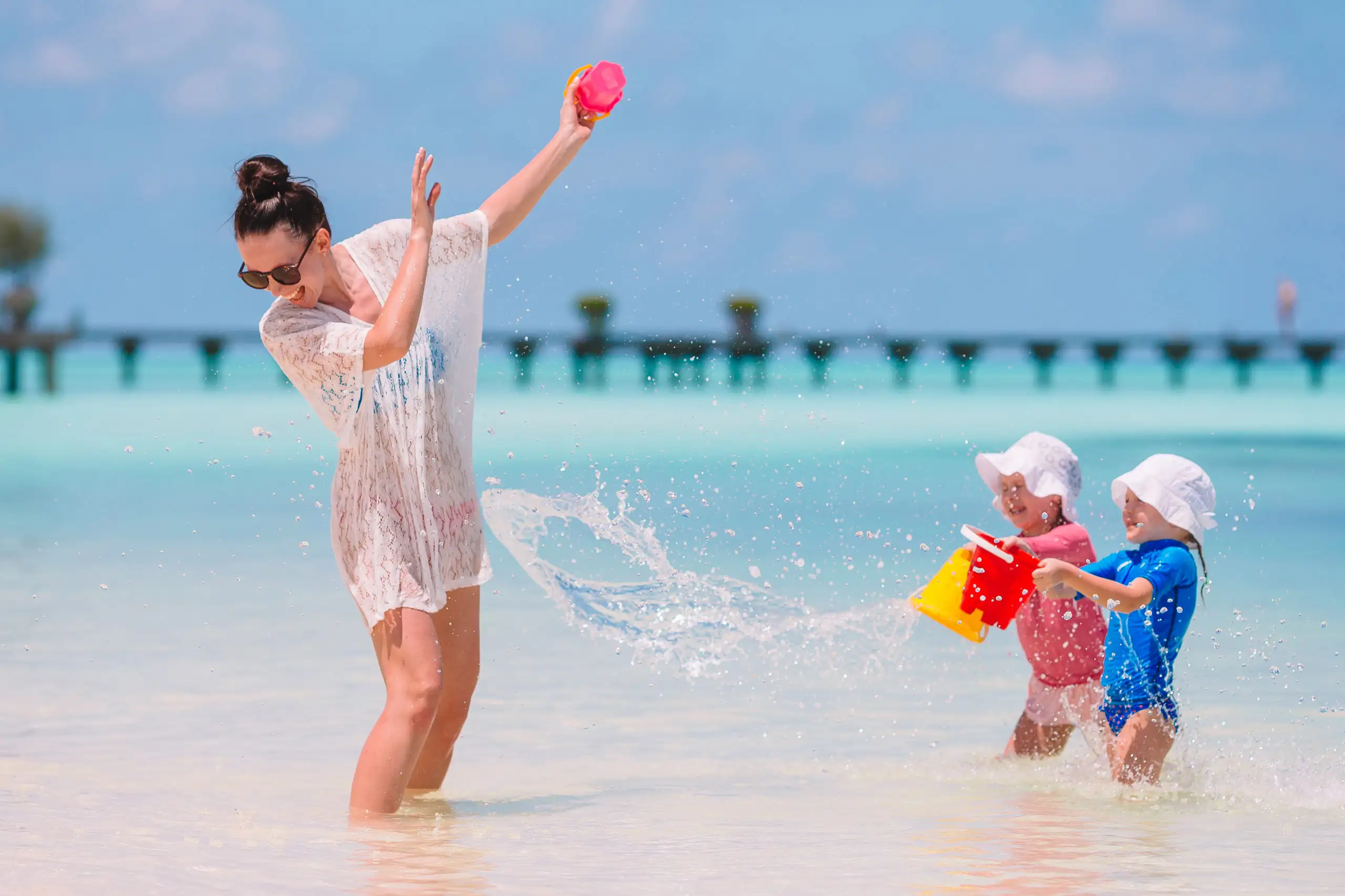 Mother and two children playing in the ocean