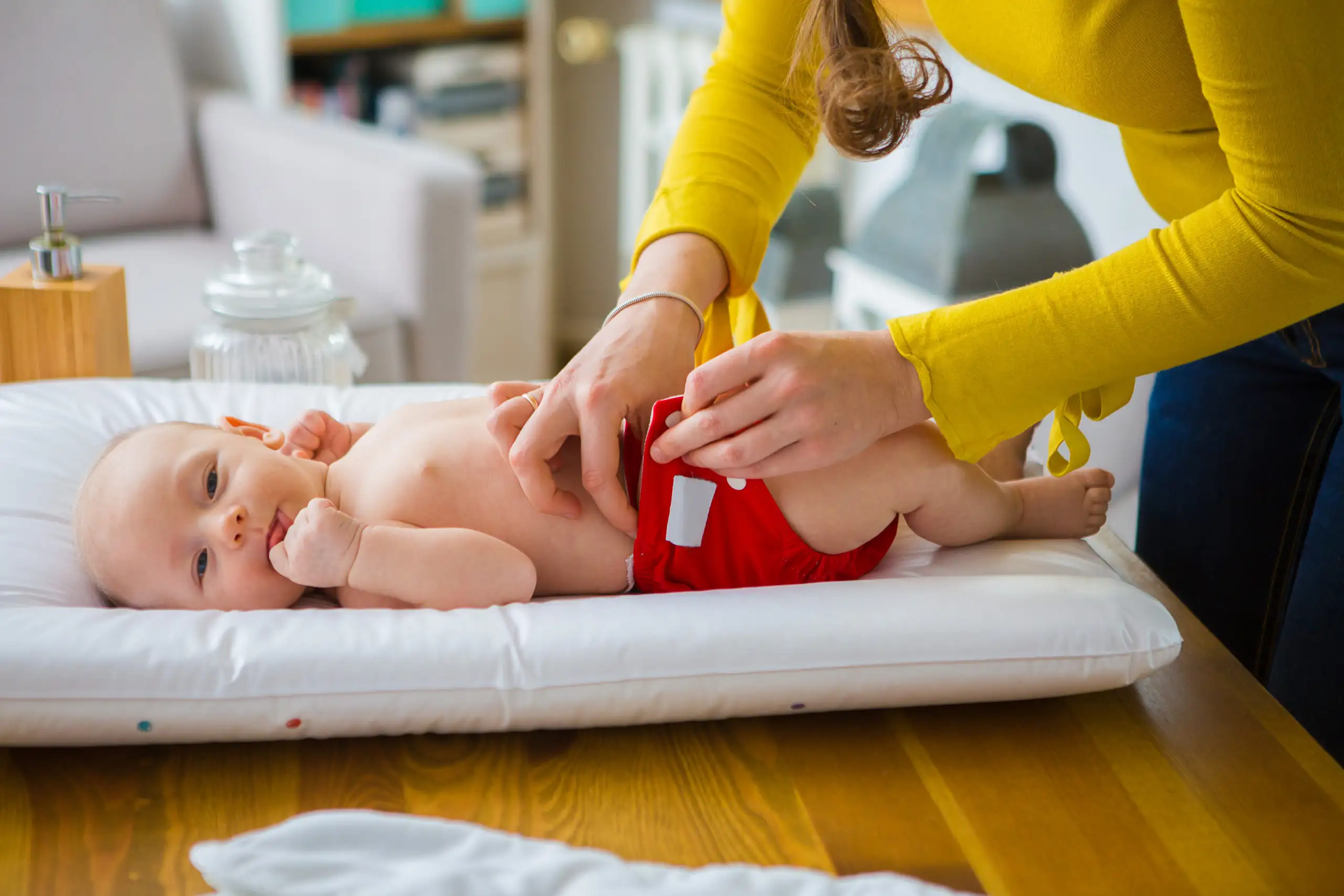 Mother changing baby's reusable diaper