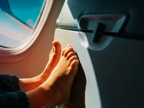 child feet plane seat; Courtesy of NadyaEugene/Shutterstock