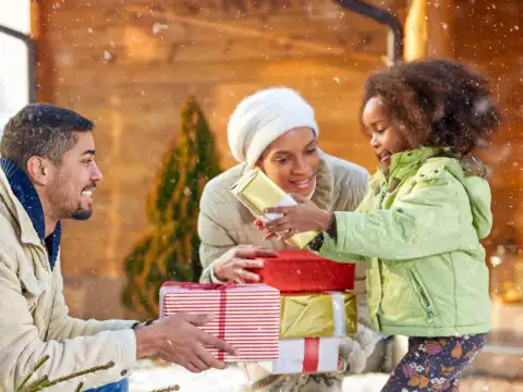 family gift giving holidays snowing; Courtesy of Lucky Business /Shutterstock