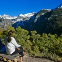 family mom and daughter sit on top of mountain and look at view; Courtesy Colorado Tourism Office