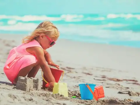 Little Girl Playing with Sand Toys on the Beach;NadyaEugene/Shutterstock.com