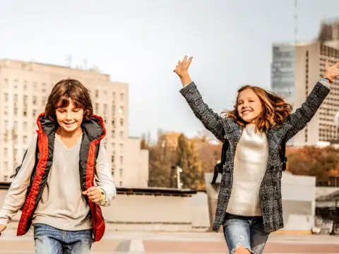 two kids running wearing fall jackets; Courtesy of By YAKOBCHUK VIACHESLAV/Shutterstock