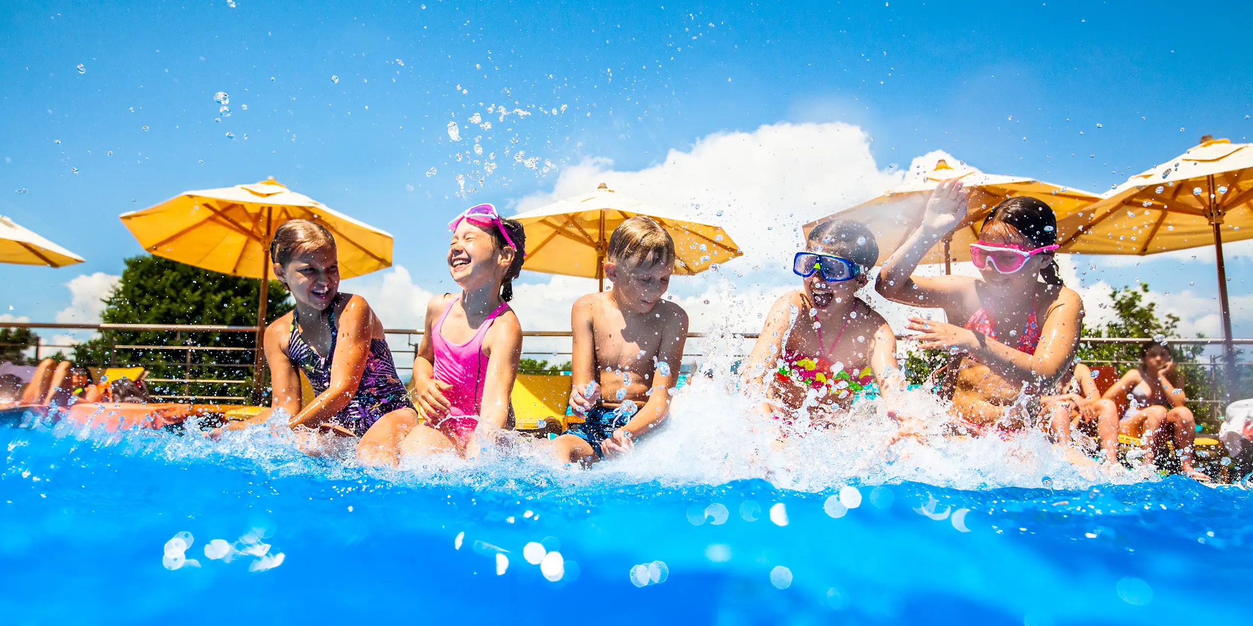 Children play fun with splashes on the side of the pool at the resort; Courtesy of YanLev/Shutterstock