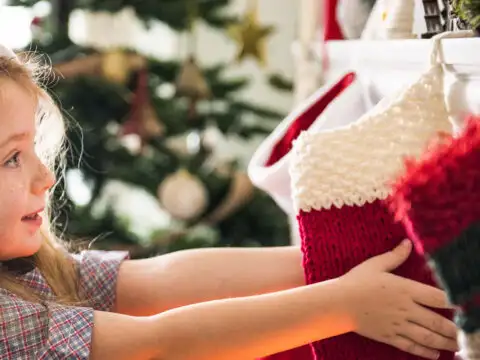 girl holding christmas stocking; Courtesy of Rawpixel/Shutterstock