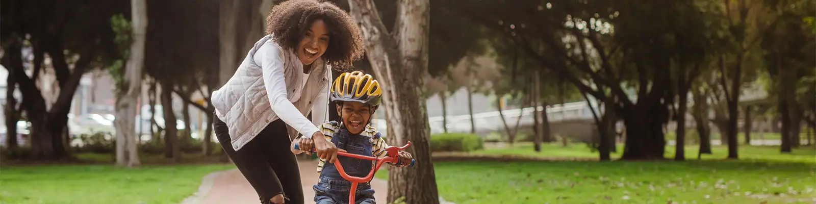 Mom teaching child how to ride a bike