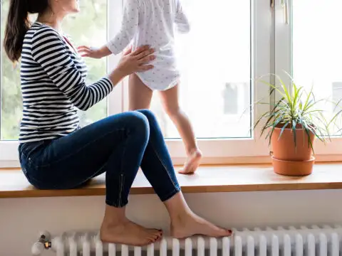 Mother with her little daughter looking out of window; Courtesy of halfpoint/Shutterstock