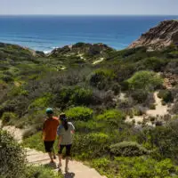 two people walking down steps to torrey pines beach in san diego